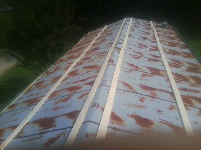 Rusted metal roof panels with new wood purlins before replacement — Storm Damage Roof Repair in Erie by Roofing Brothers